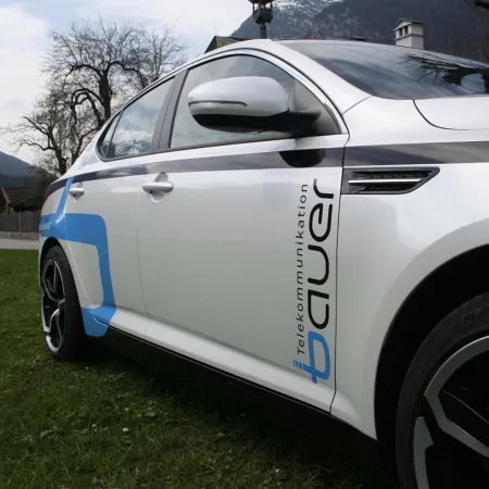 Weißes Auto mit blauen Akzenten in einer Landschaft