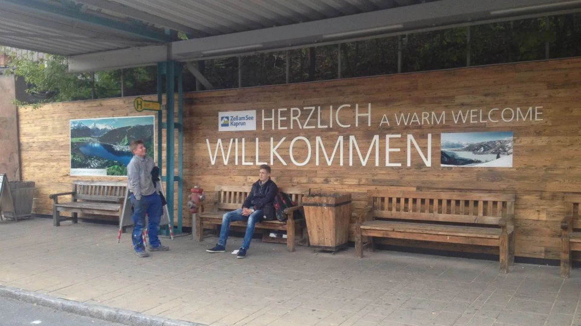 Wartebereich mit Willkommenstafel und zwei Personen