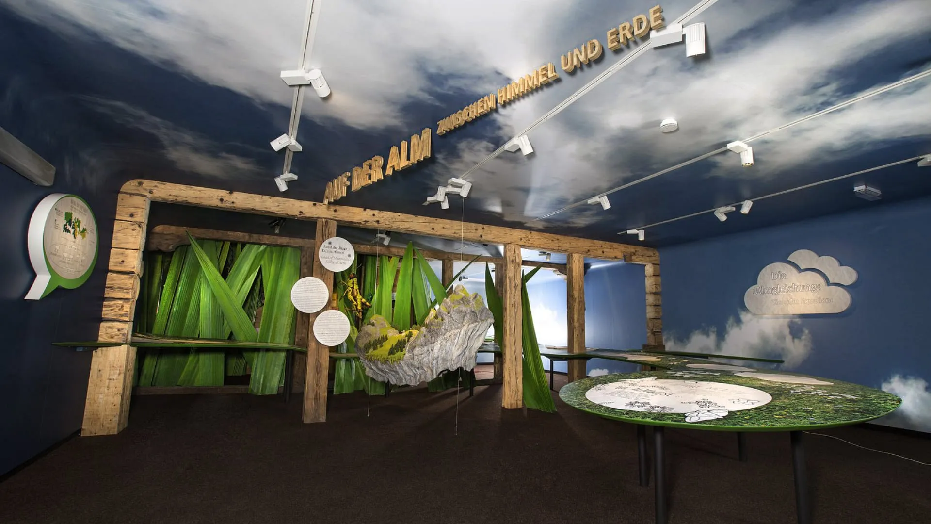 Ausstellungsraum mit Holzstrukturen und Berglandschaft