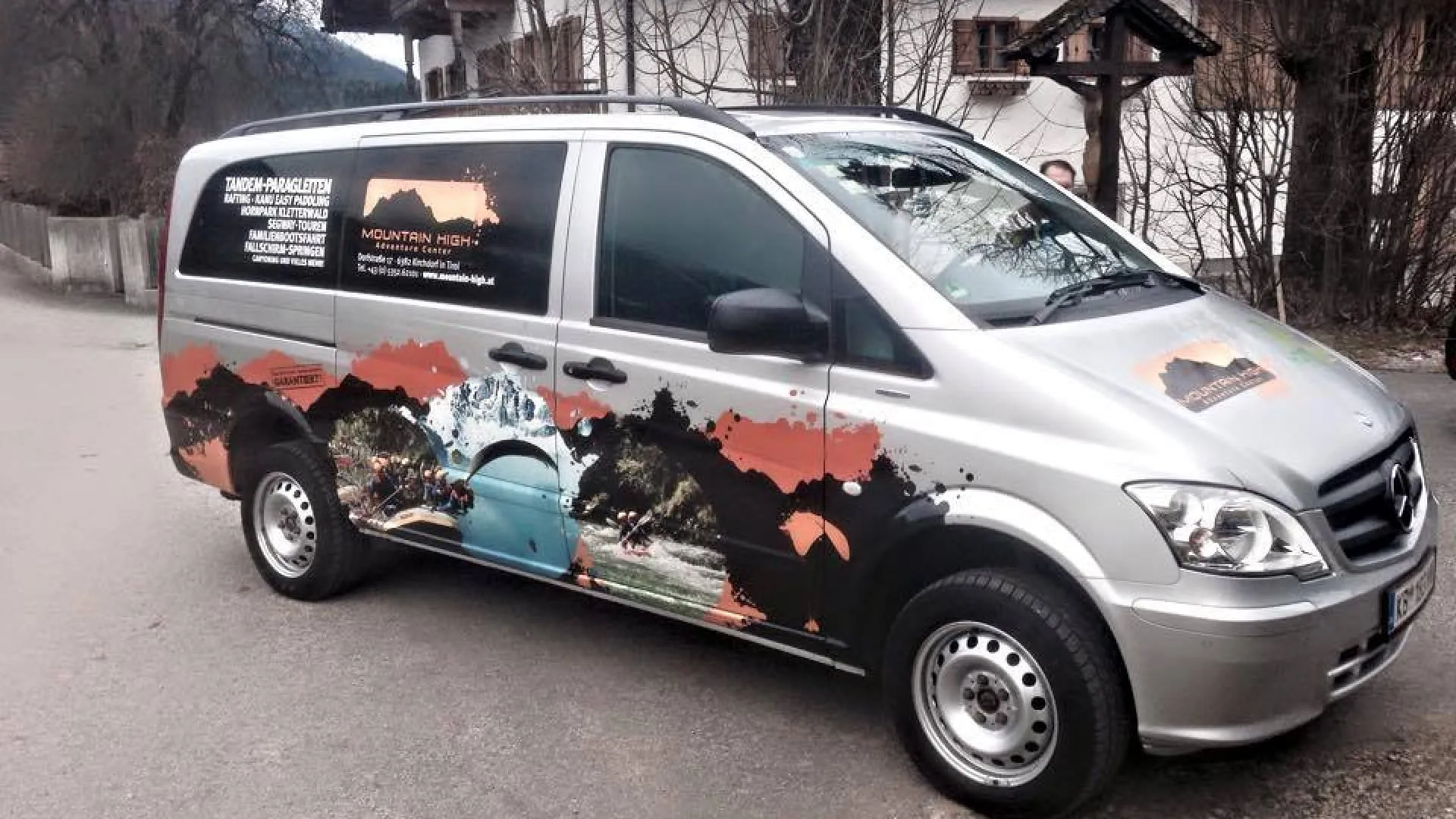 Silberner Van mit buntem Design in ländlicher Umgebung