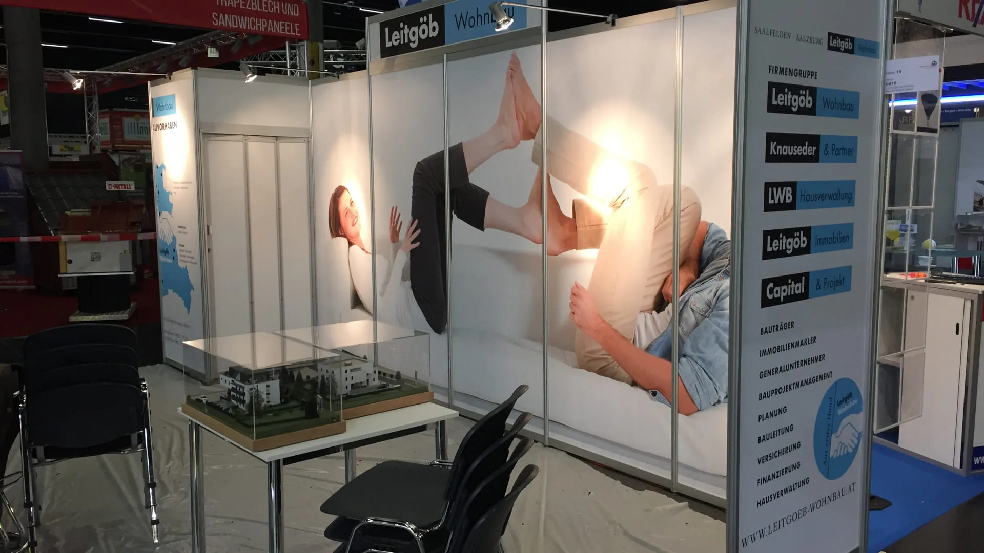 Messestand mit Plakaten und Modell auf einem Tisch