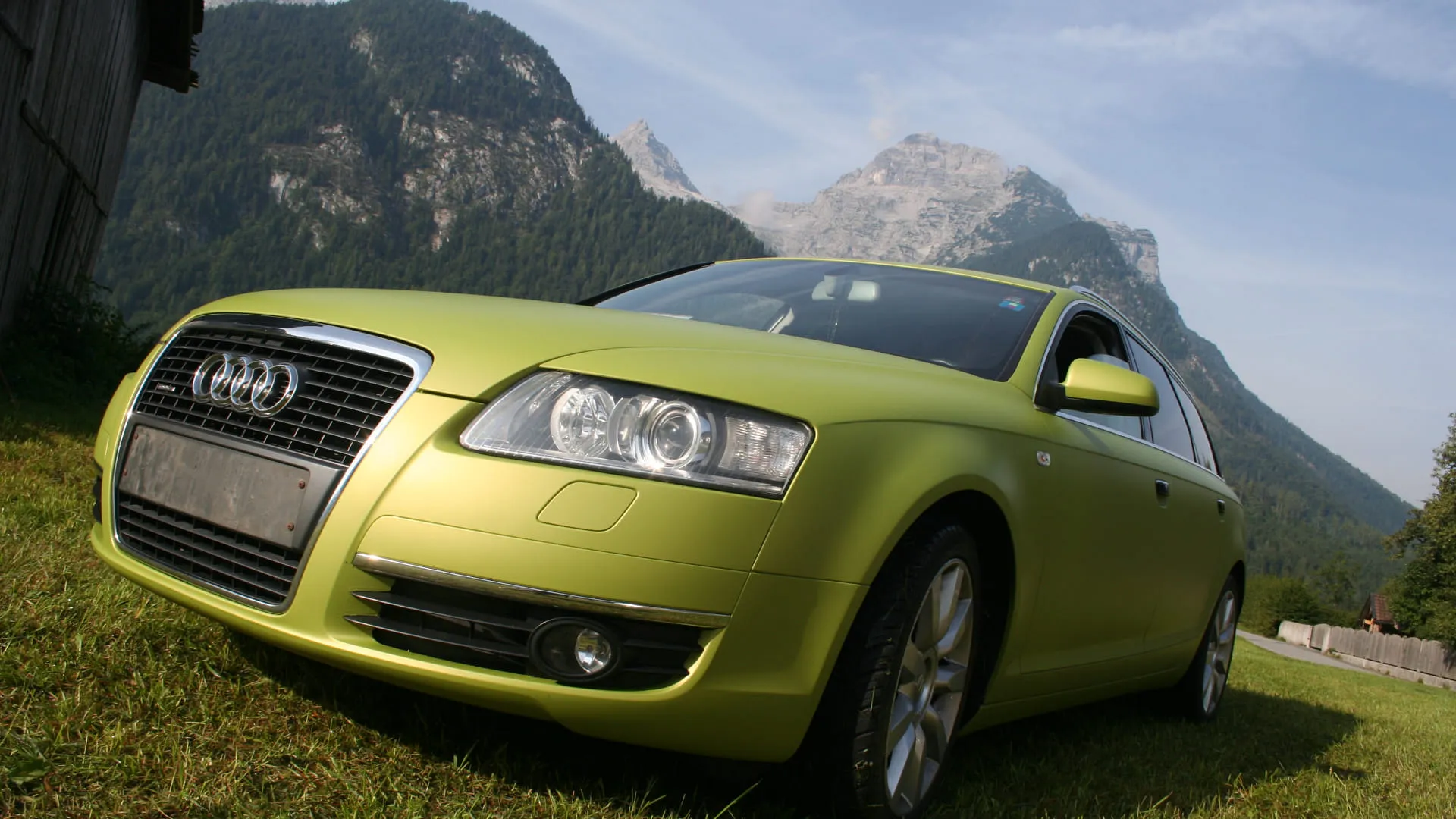 Grünes Audi-Auto vor Bergen im Freien
