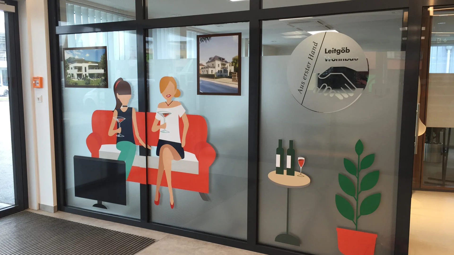 Büro mit Glaswand und bunten Wanddekorationen