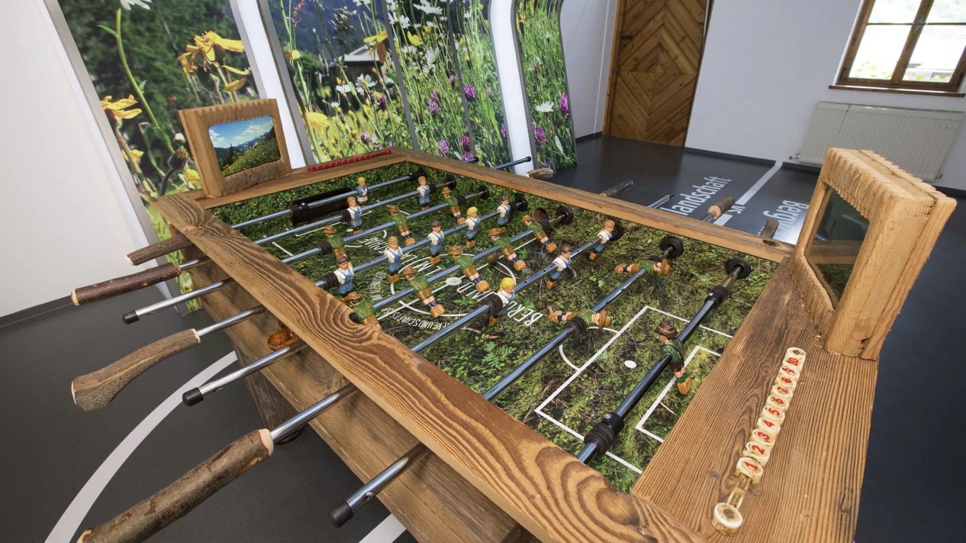 Kicker aus Holz mit Gras-Design in einem Raum